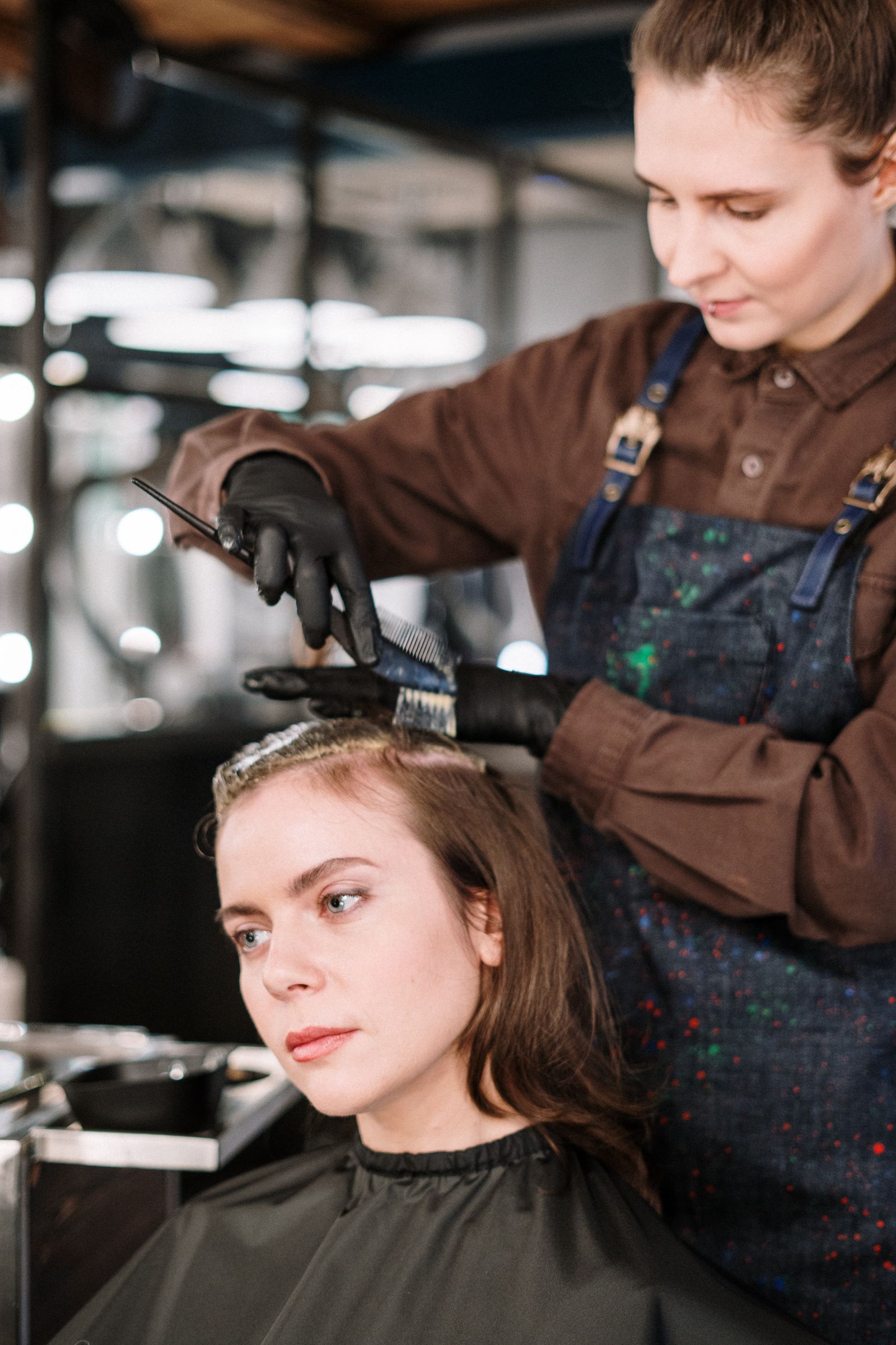 Friseurin trägt Haarfarbe im Salon auf
